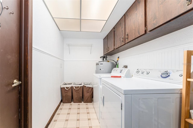 11307 Sandpine Rd, Riverview, FL 33569 - laundry area featuring cabinet space, water heater, washing machine and dryer, light flooring, and a wainscoted wall