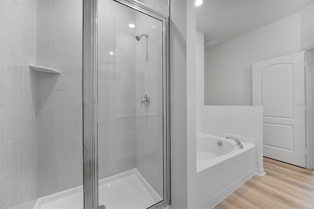 247 Big Sioux Dr, Poinciana, FL 34759 - full bathroom with a stall shower, a bath, and wood finished floors