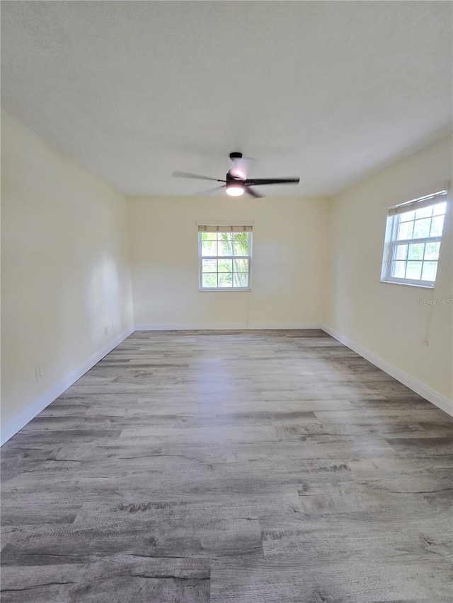 8300 Bardmoor Blvd Unit 110, Seminole, FL 33777 - empty room featuring plenty of natural light, a ceiling fan, and wood finished floors