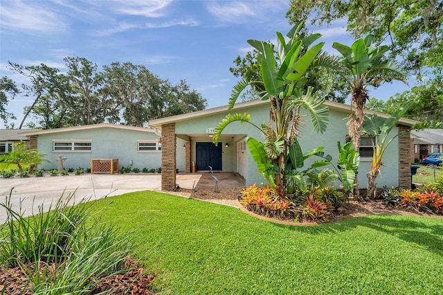 21906 Shamu Dr, Land O Lakes, FL 34639 - view of front of house featuring stucco siding, a front yard, and concrete driveway