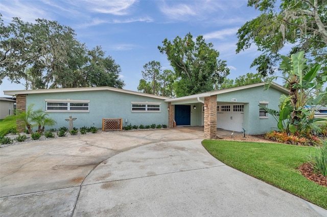 21906 Shamu Dr, Land O Lakes, FL 34639 - view of front of property with stucco siding, driveway, a carport, and a front lawn