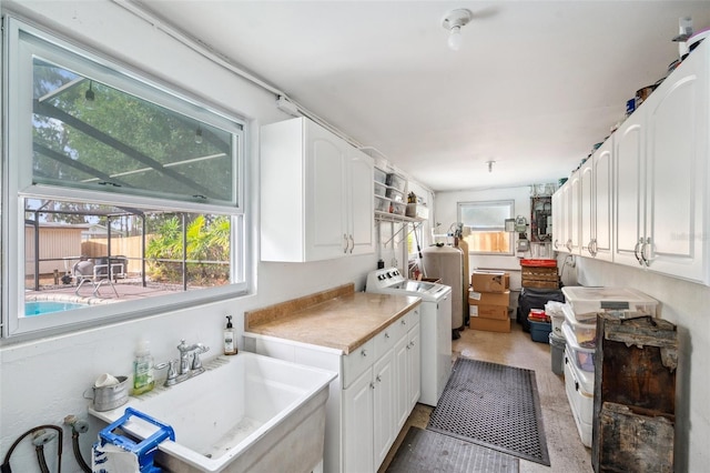 21906 Shamu Dr, Land O Lakes, FL 34639 - kitchen featuring washing machine and clothes dryer, white cabinets, and light countertops