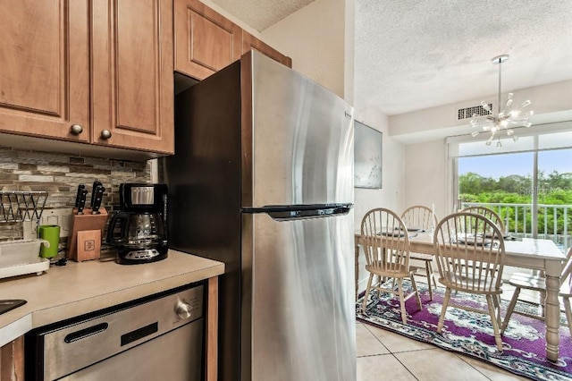 3315 58th Ave S Unit 311, Saint Petersburg, FL 33712 - kitchen featuring stainless steel appliances, a chandelier, backsplash, a textured ceiling, and light countertops