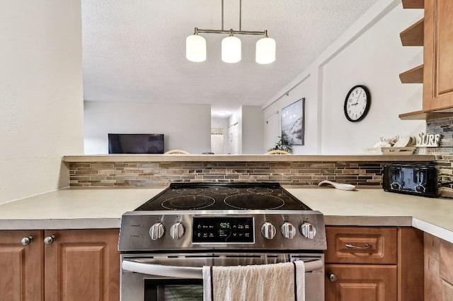 3315 58th Ave S Unit 311, Saint Petersburg, FL 33712 - kitchen with electric stove, decorative backsplash, a textured ceiling, light countertops, and brown cabinetry