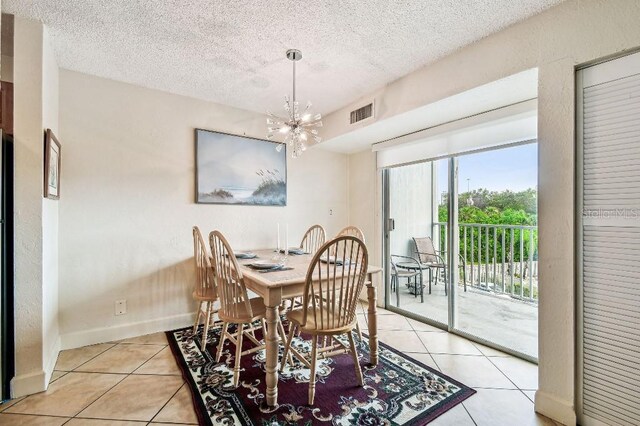 3315 58th Ave S Unit 311, Saint Petersburg, FL 33712 - dining room featuring light tile patterned floors, a chandelier, and a textured ceiling