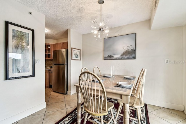 3315 58th Ave S Unit 311, Saint Petersburg, FL 33712 - dining area featuring a textured ceiling, light tile patterned flooring, and a chandelier