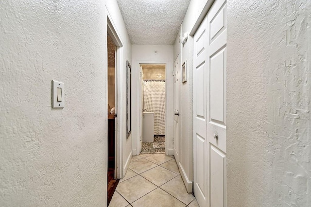 3315 58th Ave S Unit 311, Saint Petersburg, FL 33712 - corridor featuring a textured wall, light tile patterned floors, and a textured ceiling