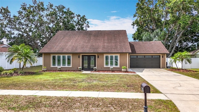 7206 Timber Ct, Tampa, FL 33625 - view of front of home with french doors, stucco siding, a garage, driveway, and roof with shingles