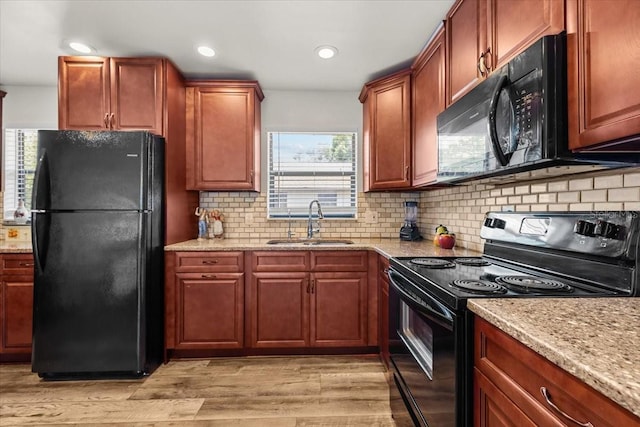 4945 91st Ave N Unit 30, Pinellas Park, FL 33782 - kitchen featuring black appliances, light wood-style floors, light stone counters, backsplash, and recessed lighting