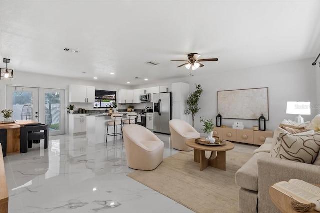 6370 Elmhurst Dr, Pinellas Park, FL 33782 - living room with light marble finish flooring, a ceiling fan, french doors, and recessed lighting