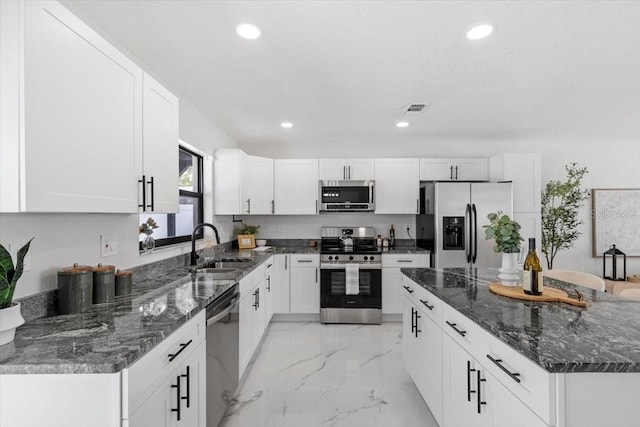 6370 Elmhurst Dr, Pinellas Park, FL 33782 - kitchen with stainless steel appliances, recessed lighting, light marble finish floors, white cabinetry, and dark stone countertops