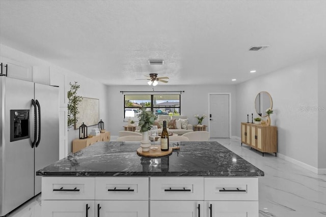 6370 Elmhurst Dr, Pinellas Park, FL 33782 - kitchen with stainless steel refrigerator with ice dispenser, light marble finish floors, a ceiling fan, dark stone countertops, and white cabinets