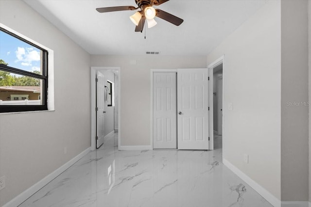 6370 Elmhurst Dr, Pinellas Park, FL 33782 - unfurnished bedroom featuring a closet, marble finish flooring, and a ceiling fan