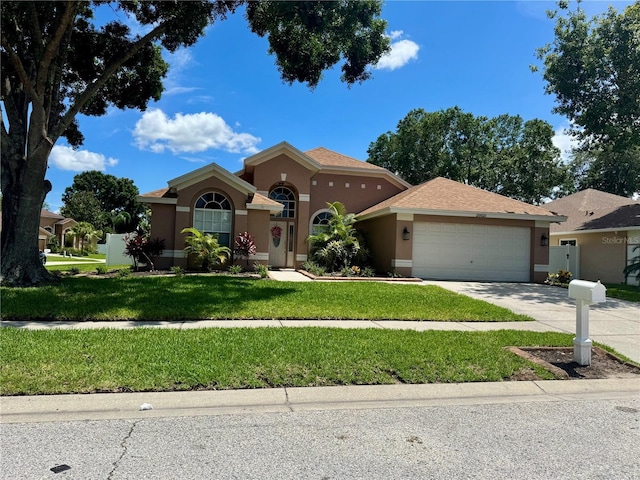 28826 Windover St, Wesley Chapel, FL 33545 - mediterranean / spanish house featuring stucco siding, a garage, driveway, and a front yard