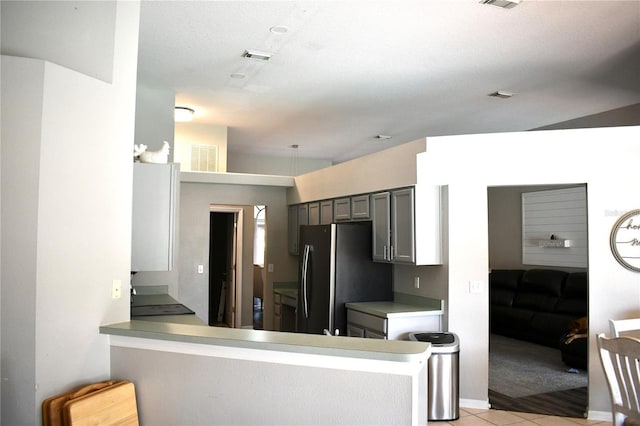 28826 Windover St, Wesley Chapel, FL 33545 - kitchen with freestanding refrigerator, light colored carpet, light tile patterned floors, a peninsula, and gray cabinetry