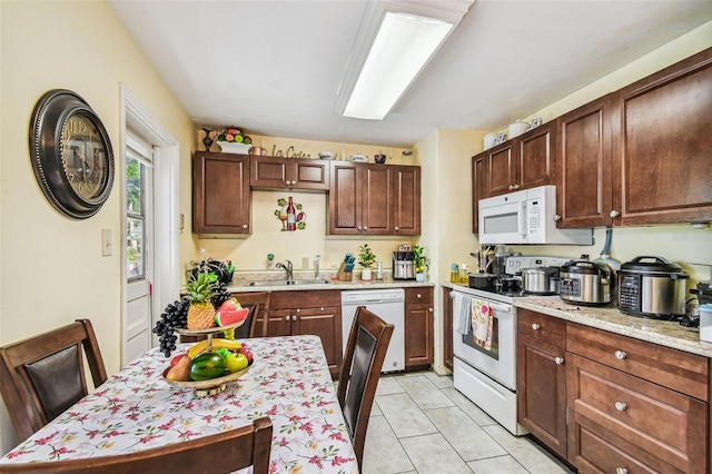 1711 W Followthru Dr, Tampa, FL 33612 - kitchen with white appliances and light tile patterned flooring