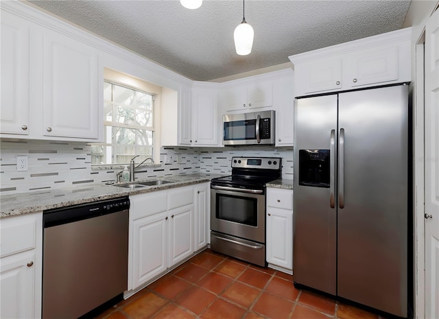 945 Hamilton Ct, Palm Harbor, FL 34683 - kitchen featuring stainless steel appliances, white cabinetry, tasteful backsplash, a textured ceiling, and decorative light fixtures