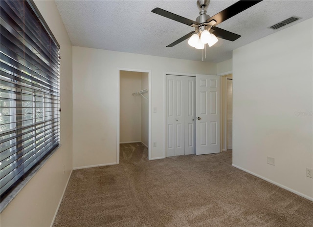 945 Hamilton Ct, Palm Harbor, FL 34683 - unfurnished bedroom featuring carpet, a textured ceiling, a closet, and a ceiling fan