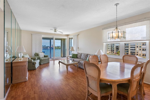 7892 Sailboat Key Blvd S Unit 408, South Pasadena, FL 33707 - dining room featuring wood finished floors, a chandelier, a textured ceiling, and a ceiling fan