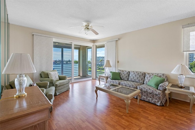 7892 Sailboat Key Blvd S Unit 408, South Pasadena, FL 33707 - living area with plenty of natural light, a ceiling fan, wood finished floors, a textured ceiling, and a water view