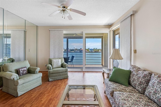 7892 Sailboat Key Blvd S Unit 408, South Pasadena, FL 33707 - living area featuring healthy amount of natural light, wood finished floors, a ceiling fan, a textured ceiling, and a water view