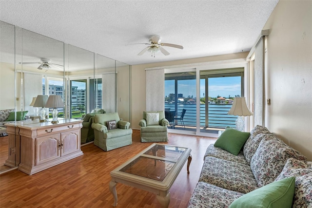 7892 Sailboat Key Blvd S Unit 408, South Pasadena, FL 33707 - living room featuring a ceiling fan, a textured ceiling, healthy amount of natural light, and wood finished floors