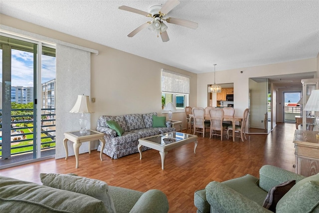 7892 Sailboat Key Blvd S Unit 408, South Pasadena, FL 33707 - living room featuring a textured ceiling, a chandelier, wood finished floors, and ceiling fan