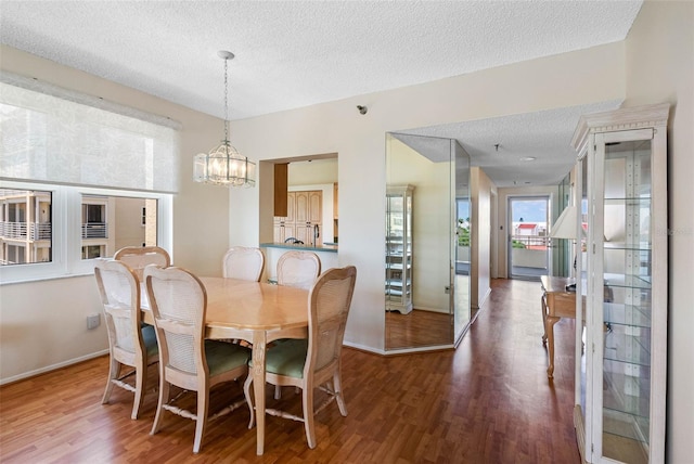 7892 Sailboat Key Blvd S Unit 408, South Pasadena, FL 33707 - dining room featuring plenty of natural light, wood finished floors, a textured ceiling, and a chandelier