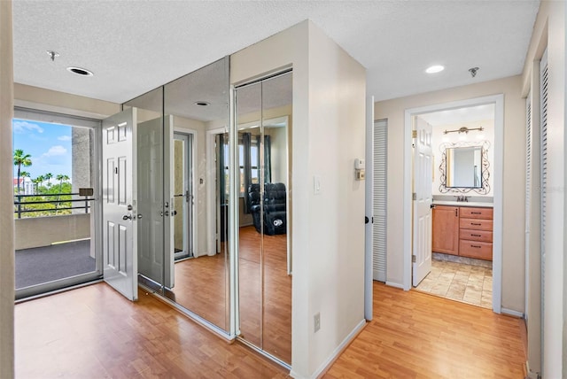 7892 Sailboat Key Blvd S Unit 408, South Pasadena, FL 33707 - hallway with light wood finished floors, a textured ceiling, and recessed lighting