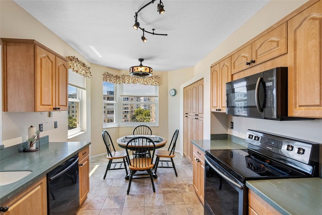 7892 Sailboat Key Blvd S Unit 408, South Pasadena, FL 33707 - kitchen with black appliances, dark countertops, a textured ceiling, track lighting, and light stone finish floors