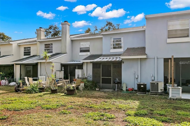 6681 121st Ave Unit I, Largo, FL 33773 - rear view of property with a standing seam roof, a metal roof, stucco siding, and a yard