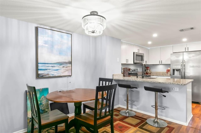 6681 121st Ave Unit I, Largo, FL 33773 - dining space featuring wood finished floors, recessed lighting, and a chandelier