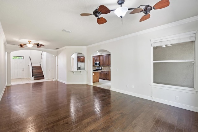 4920 Anniston Cir, Tampa, FL 33647 - unfurnished living room with arched walkways, ceiling fan, crown molding, stairs, and wood finished floors
