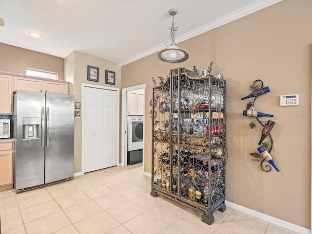 7606 Berna Ln, Land O Lakes, FL 34637 - kitchen featuring appliances with stainless steel finishes, washer / clothes dryer, crown molding, pendant lighting, and light tile patterned flooring