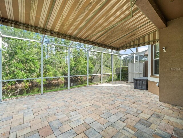 7606 Berna Ln, Land O Lakes, FL 34637 - unfurnished sunroom with a water view, view of wooded area, and lofted ceiling