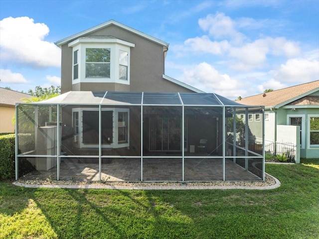 7606 Berna Ln, Land O Lakes, FL 34637 - rear view of property with stucco siding, a lawn, a patio area, and glass enclosure