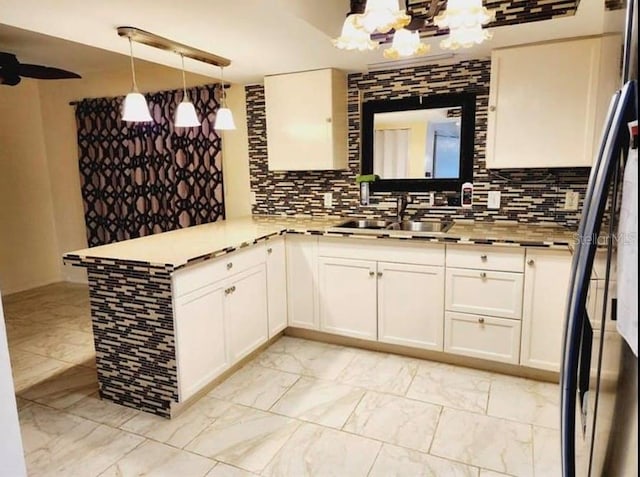 1918 Crown Park Dr, Valrico, FL 33594 - kitchen featuring freestanding refrigerator, a chandelier, a peninsula, tasteful backsplash, and white cabinetry