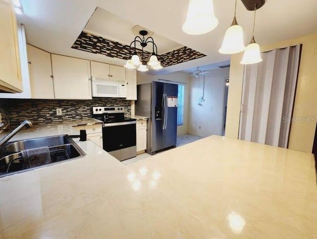 1918 Crown Park Dr, Valrico, FL 33594 - kitchen featuring stainless steel range with electric stovetop, white microwave, black refrigerator with ice dispenser, light countertops, and decorative backsplash