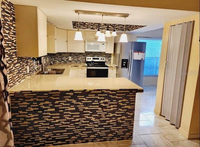 1918 Crown Park Dr, Valrico, FL 33594 - kitchen featuring stainless steel appliances, a peninsula, backsplash, light countertops, and pendant lighting
