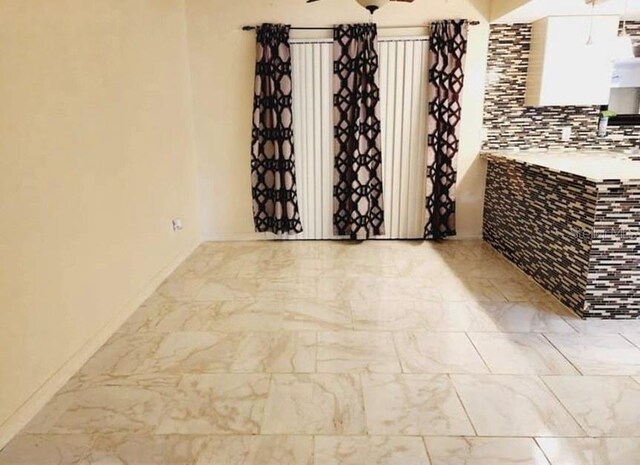 1918 Crown Park Dr, Valrico, FL 33594 - empty room featuring marble look tile flooring and a ceiling fan