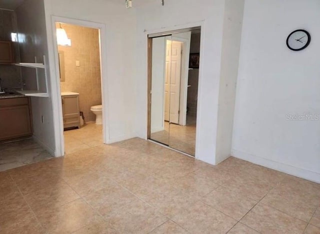 1918 Crown Park Dr, Valrico, FL 33594 - unfurnished bedroom with a closet, light tile patterned floors, and ensuite bath