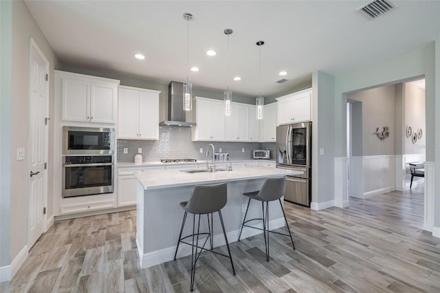 12652 Shetland Walk Dr, Lithia, FL 33547 - kitchen featuring stainless steel appliances, wall chimney exhaust hood, light countertops, light wood finished floors, and white cabinetry