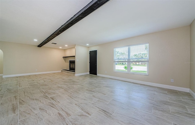 7332 Janczlik Dr, New Port Richey, FL 34652 - unfurnished living room featuring beam ceiling, recessed lighting, arched walkways, and a fireplace with raised hearth