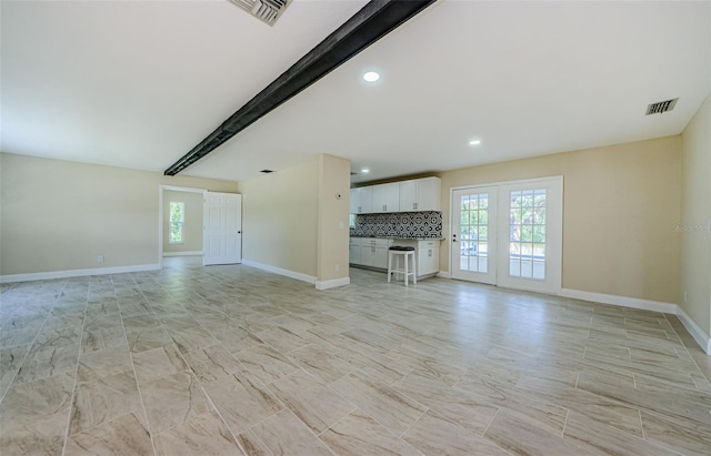 7332 Janczlik Dr, New Port Richey, FL 34652 - unfurnished living room featuring healthy amount of natural light, recessed lighting, and beamed ceiling
