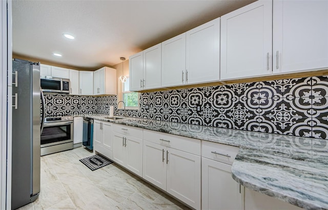 7332 Janczlik Dr, New Port Richey, FL 34652 - kitchen with stainless steel appliances, white cabinetry, light stone countertops, decorative backsplash, and recessed lighting