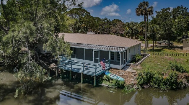 7332 Janczlik Dr, New Port Richey, FL 34652 - rear view of property featuring a sunroom, a water view, view of scattered trees, and a metal roof