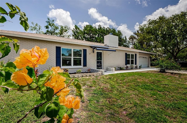 7332 Janczlik Dr, New Port Richey, FL 34652 - view of front facade with brick siding, an attached garage, a chimney, and a front yard
