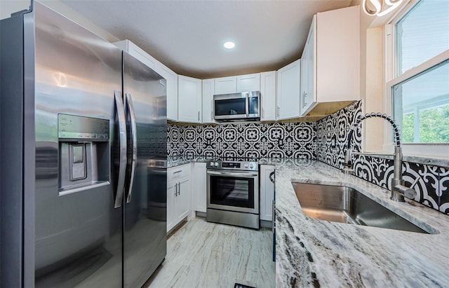 7332 Janczlik Dr, New Port Richey, FL 34652 - kitchen with appliances with stainless steel finishes, white cabinets, light stone counters, decorative backsplash, and recessed lighting