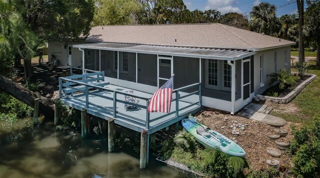 7332 Janczlik Dr, New Port Richey, FL 34652 - rear view of house featuring a sunroom, view of wooded area, and a shingled roof