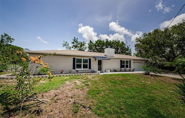 7332 Janczlik Dr, New Port Richey, FL 34652 - view of front facade featuring a garage, a chimney, a front yard, brick siding, and driveway